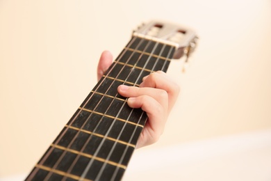 Little girl playing wooden guitar, closeup view