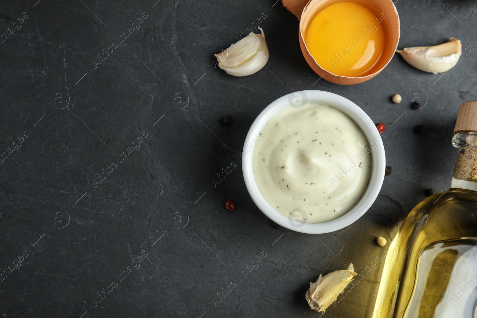 Photo of Flat lay composition with garlic sauce on dark background. Space for text