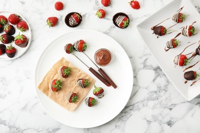 Flat lay composition with chocolate covered strawberries on marble background