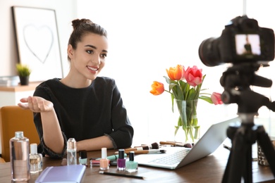 Photo of Young beauty blogger recording video at table