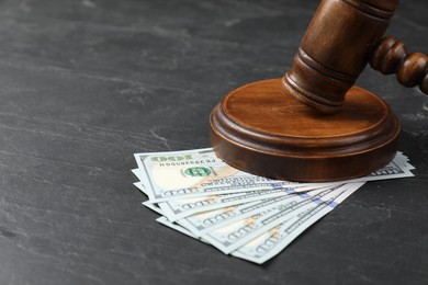 Judge's gavel and money on dark grey table, closeup. Space for text