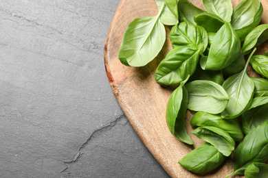 Photo of Fresh basil leaves on grey table, top view