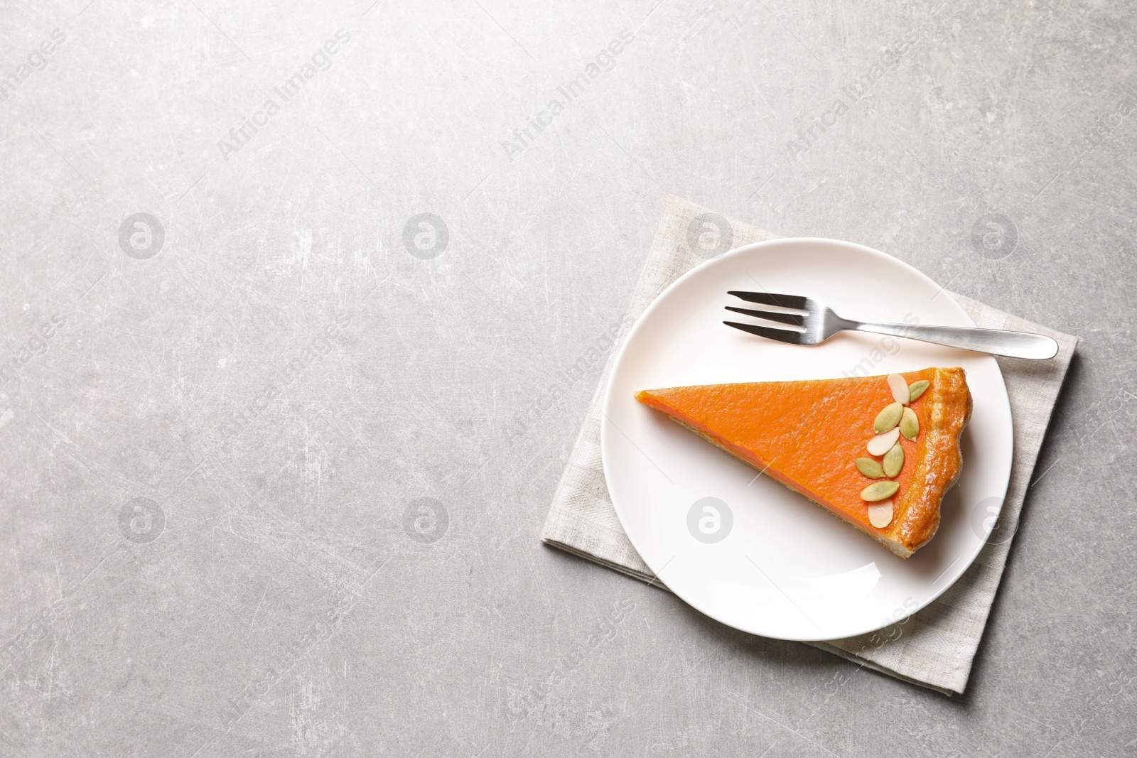 Photo of Plate with piece of fresh delicious homemade pumpkin pie on table, top view. Space for text