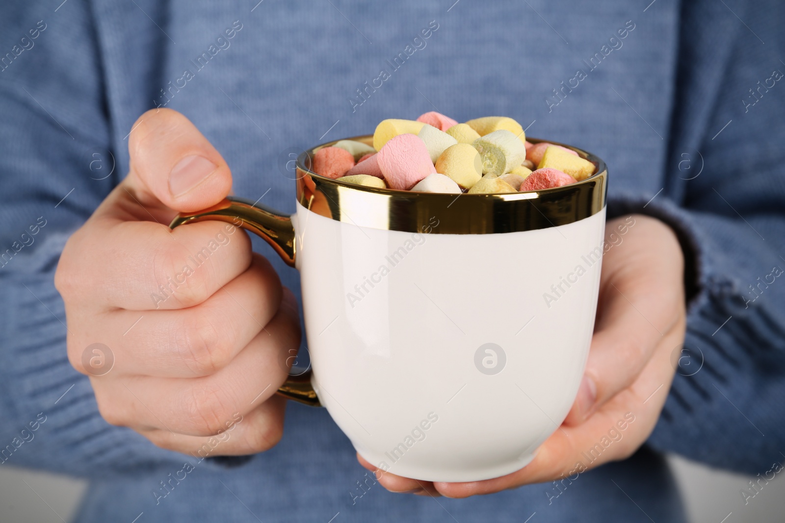 Photo of Woman holding cup of delicious hot chocolate with marshmallows, closeup