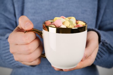 Photo of Woman holding cup of delicious hot chocolate with marshmallows, closeup