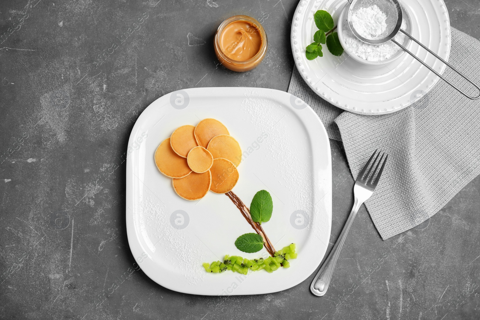 Photo of Flat lay composition with pancakes in form of flower on grey background. Creative breakfast ideas for kids