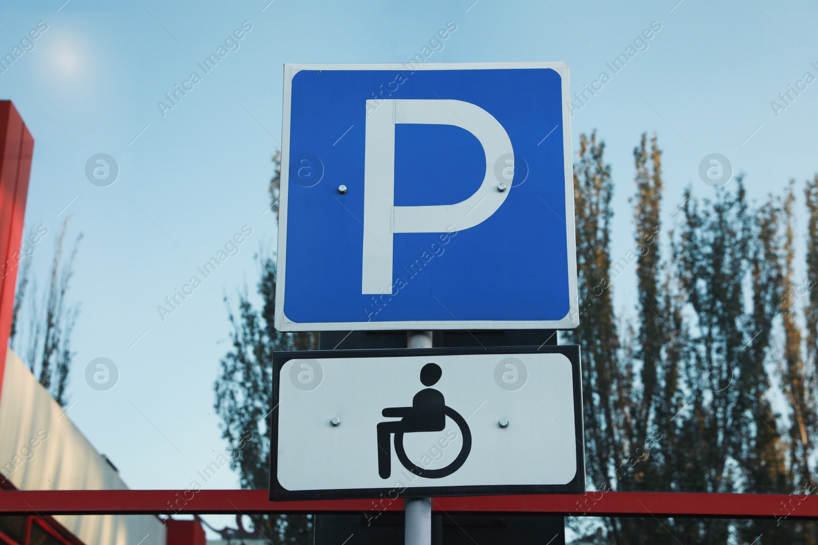 Photo of Handicapped parking sign near building window outdoors