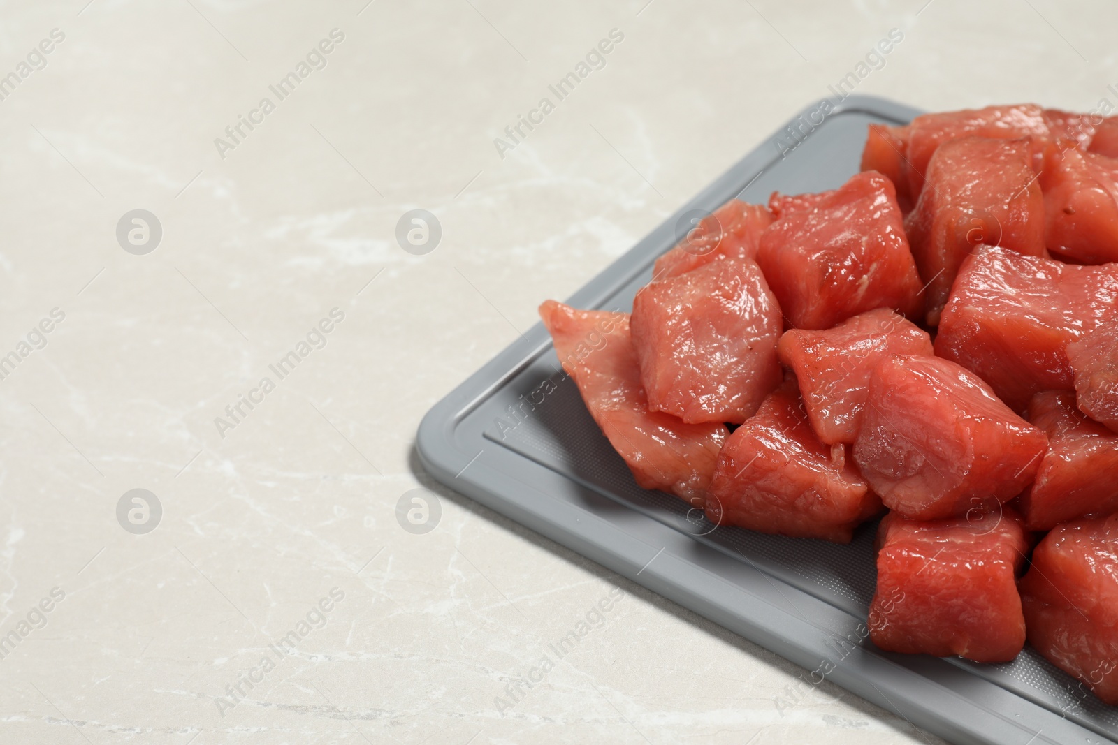 Photo of Cooking delicious goulash. Raw beef meat on light grey table, closeup. Space for text
