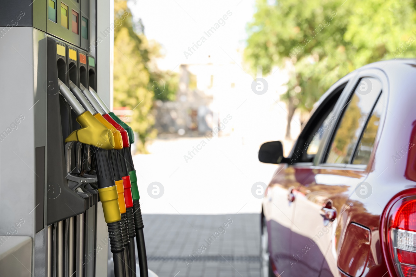 Photo of Red car at modern gas station on sunny day