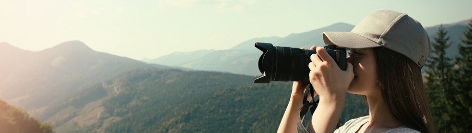 Image of Professional photographer taking picture with modern camera in mountains, space for text. Banner design