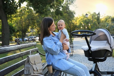 Photo of Young mother with her baby on bench in park