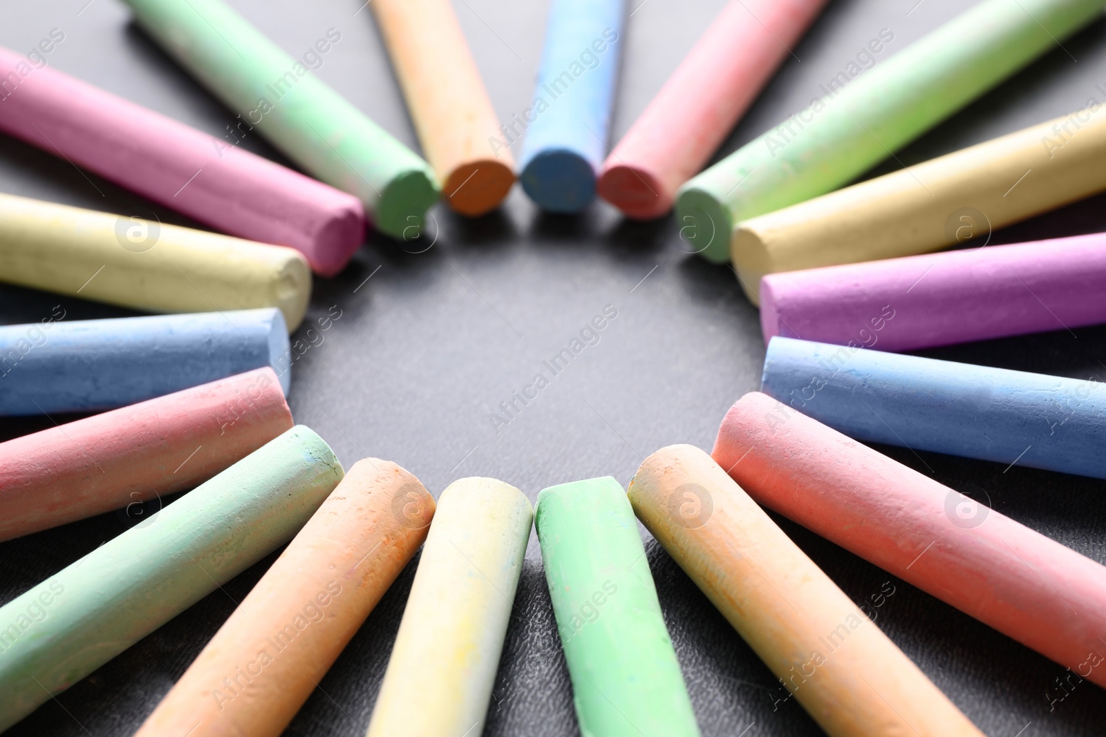 Photo of Frame made with pieces of color chalk on blackboard, closeup. Space for text