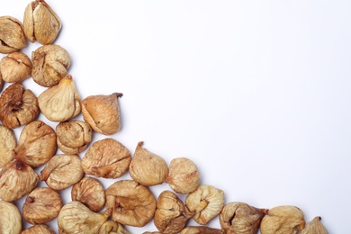 Photo of Dried figs on white background, top view with space for text. Healthy fruit