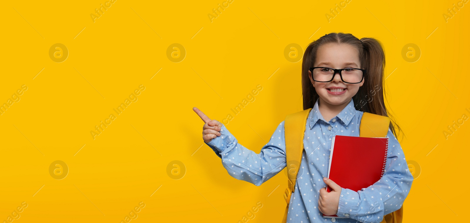 Image of First time at school. Cute little child wearing glasses on yellow background, space for text. Banner design