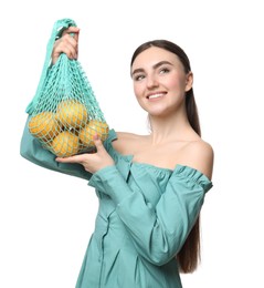 Woman with string bag of fresh lemons on white background