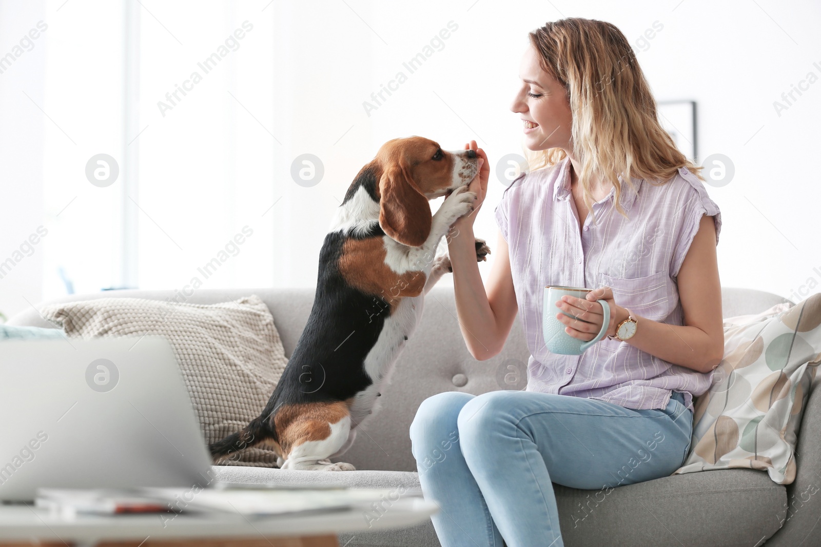 Photo of Young woman with her dog at home