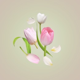 Image of Beautiful spring tulips flying on light background