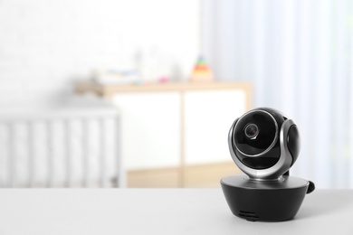 Baby camera on table in room, space for text. Video nanny