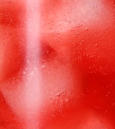 Photo of Glass of refreshing drink with ice cubes as background, closeup