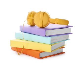 Modern headphones with hardcover books on white background