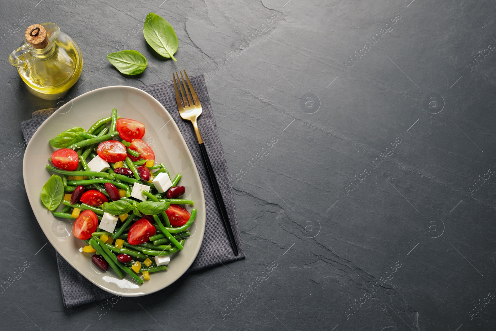 Photo of Tasty salad with green beans served on black table, flat lay. Space for text