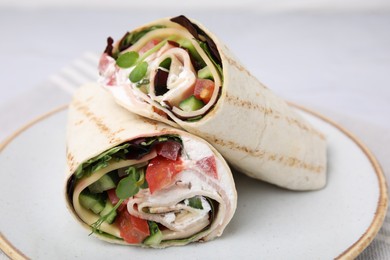 Photo of Delicious sandwich wraps with fresh vegetables on white plate, closeup