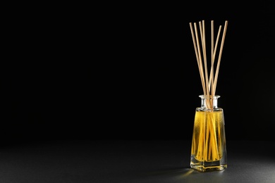 Photo of Reed air freshener on black background, space for text