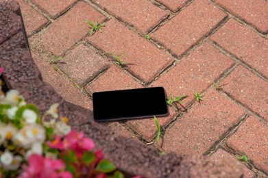 Photo of Smartphone on pavement outdoors, space for text. Lost and found