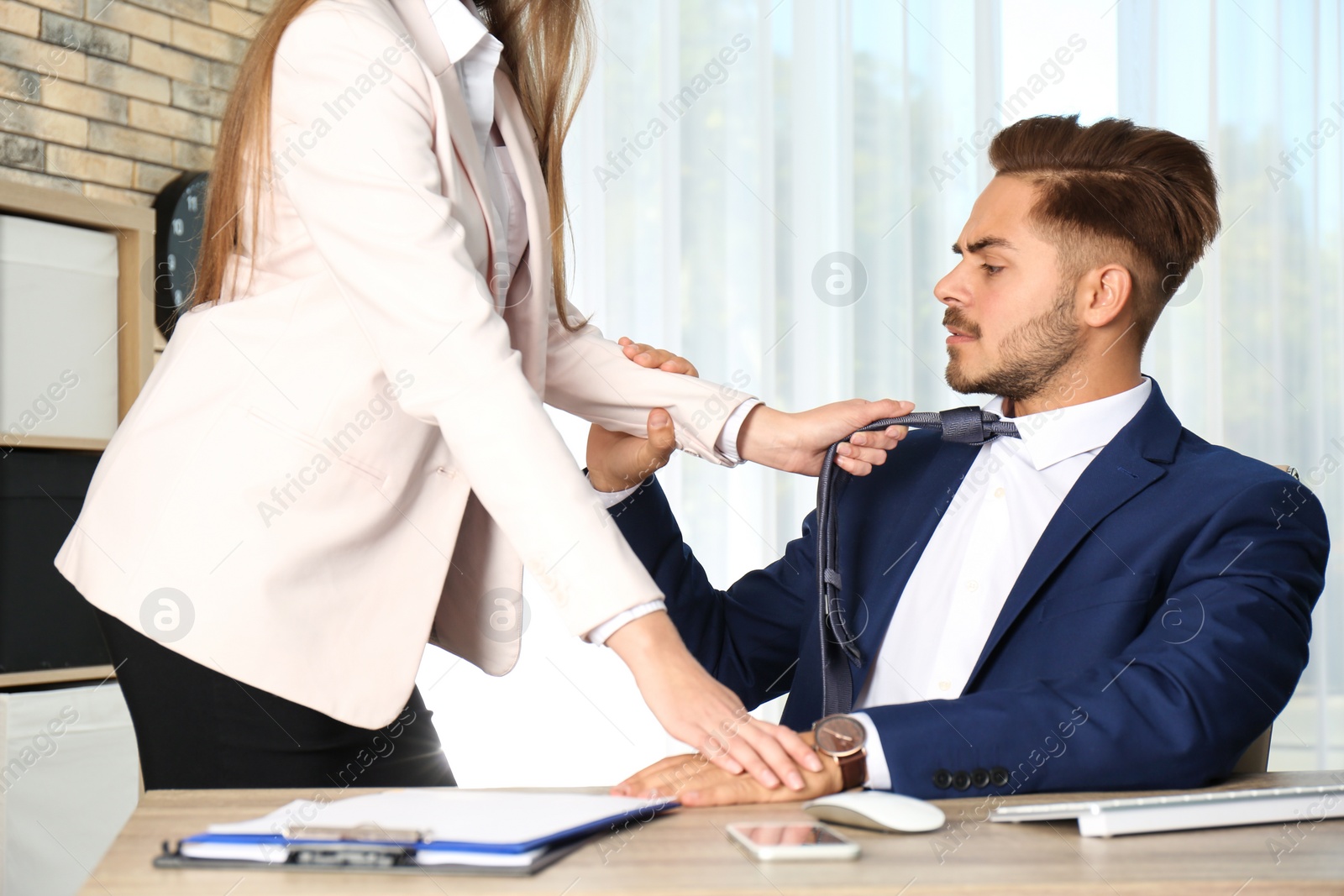 Photo of Woman molesting her male colleague in office. Sexual harassment at work