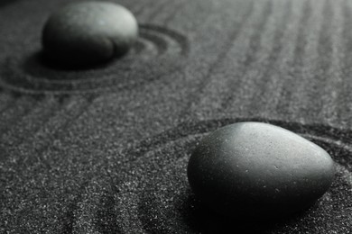Black sand with stones and beautiful pattern. Zen concept