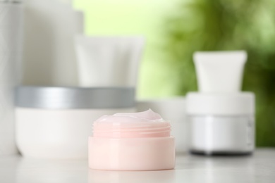 Jar of body care product on table against blurred background. Space for text