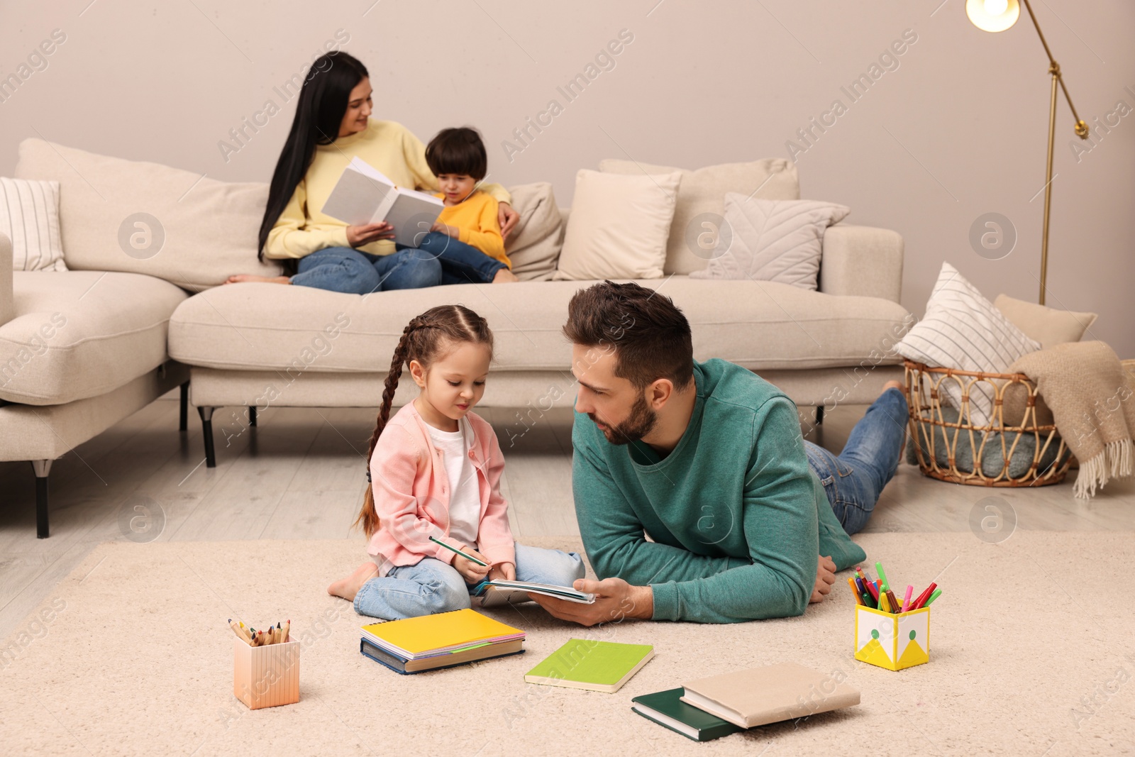 Photo of Happy family spending time together in living room