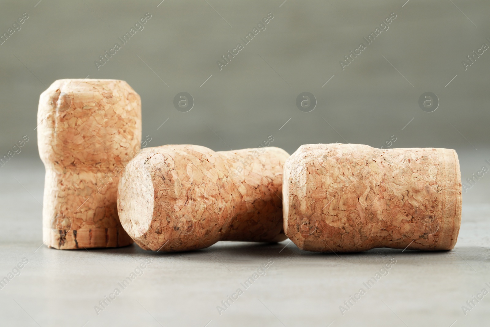 Photo of Corks of wine bottles on light grey table, closeup