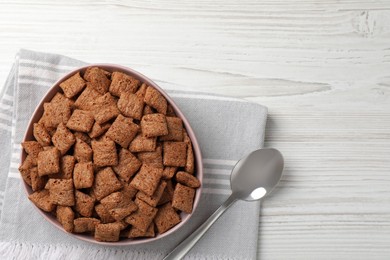 Photo of Sweet crispy corn pads in bowl and spoon on white wooden table, flat lay. Space for text