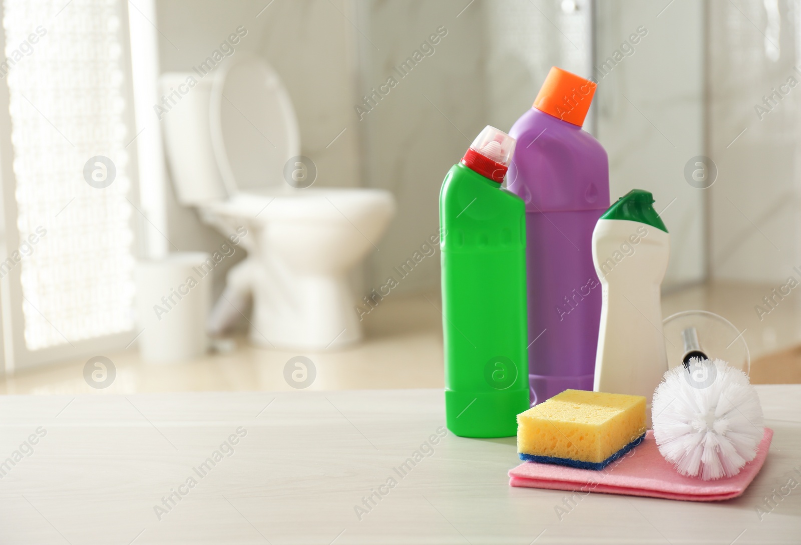 Photo of Cleaning supplies and toilet bowl in bathroom. Space for text