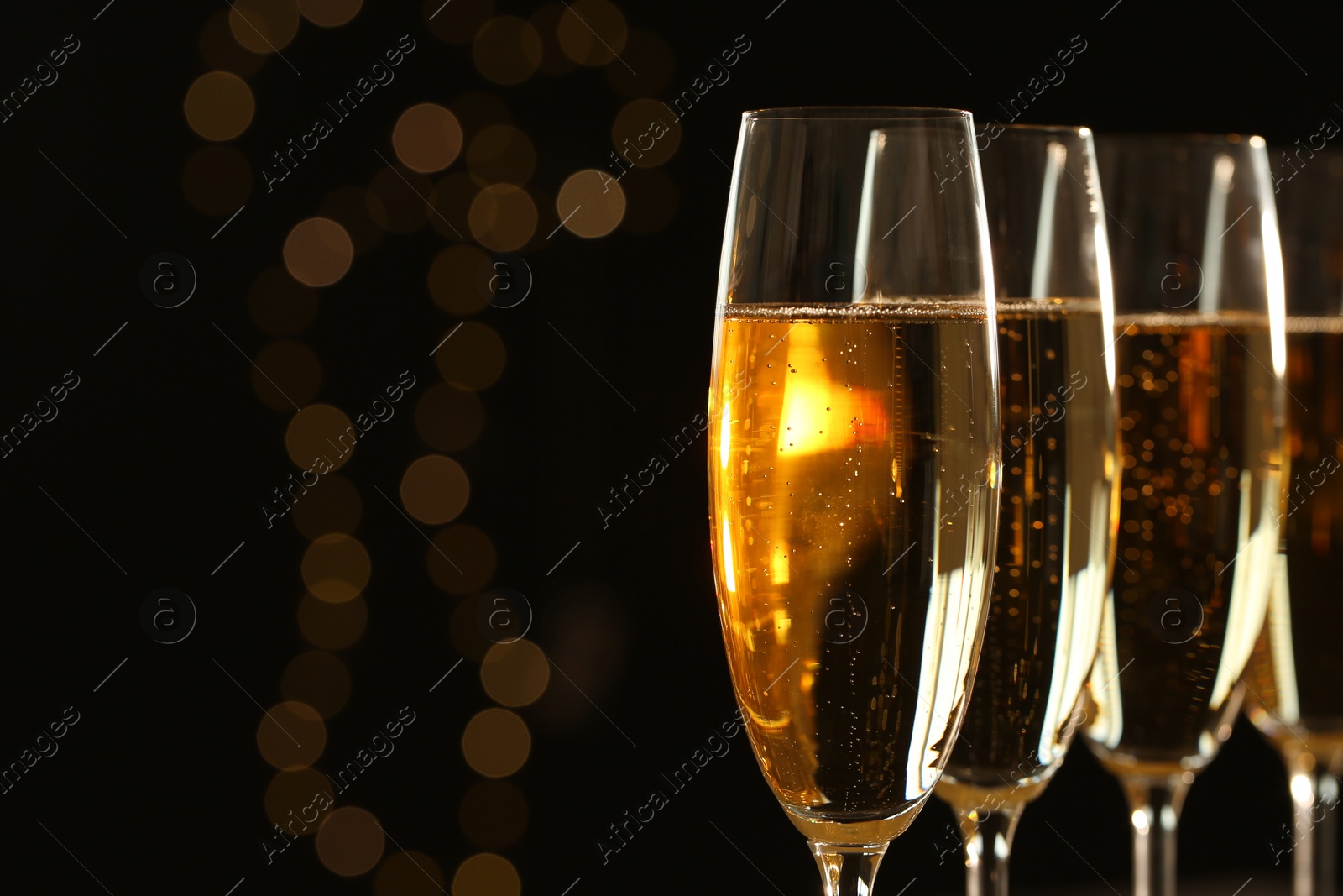 Photo of Glasses of champagne on blurred background, closeup. Space for text