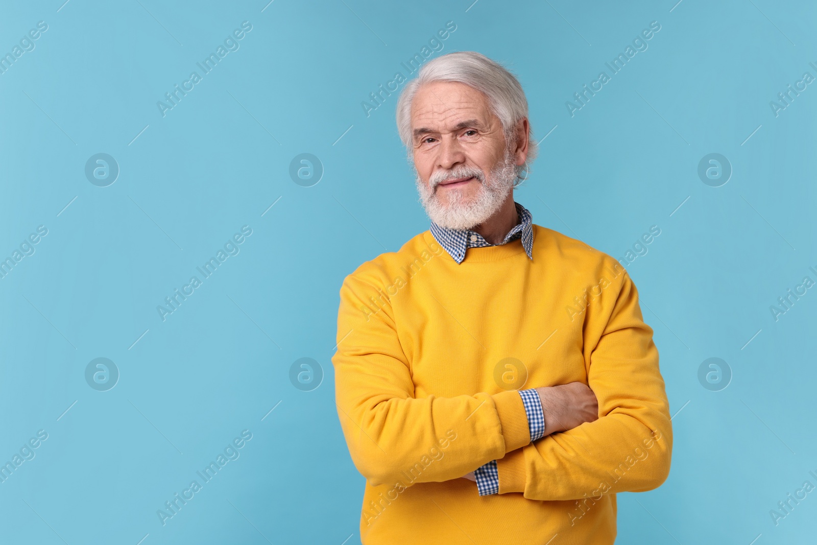 Photo of Portrait of stylish grandpa on light blue background, space for text