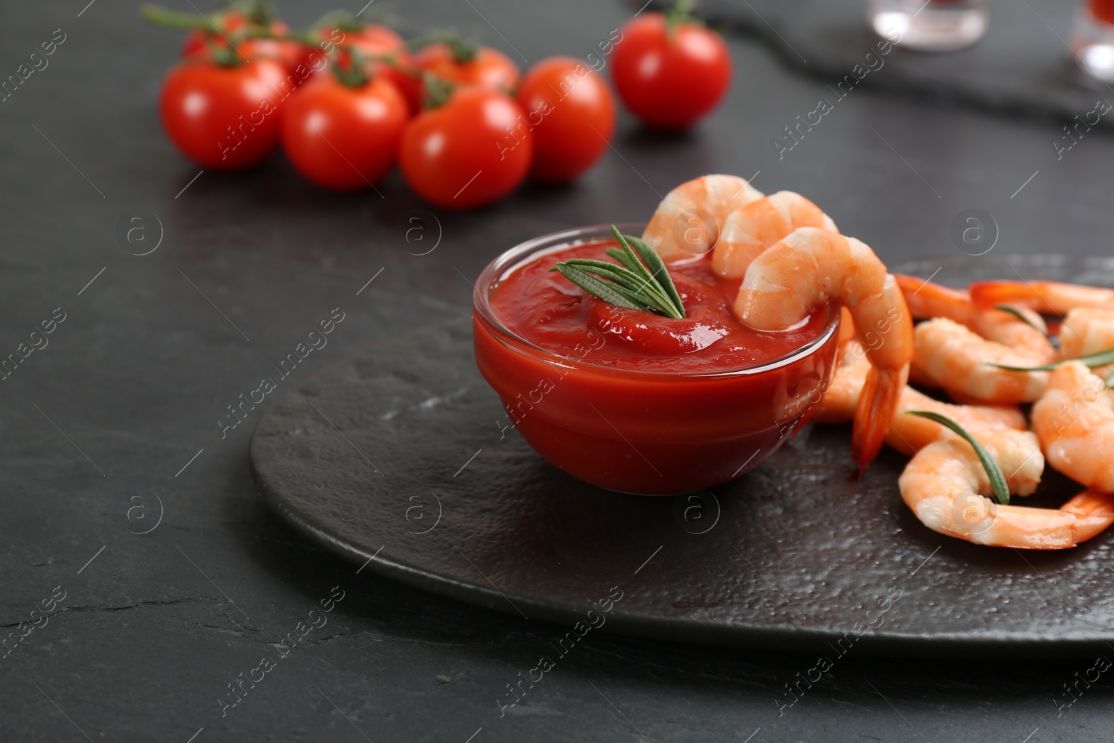 Photo of Delicious shrimp cocktail with tomato sauce served on black table