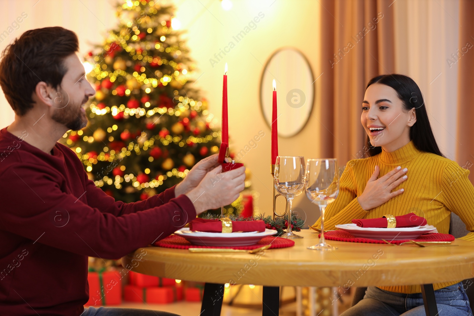 Photo of Man with engagement ring making proposal to his girlfriend at home on Christmas