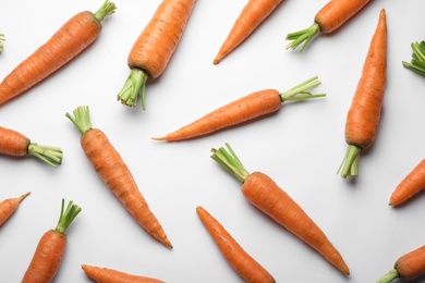 Flat lay composition with fresh carrots on color background