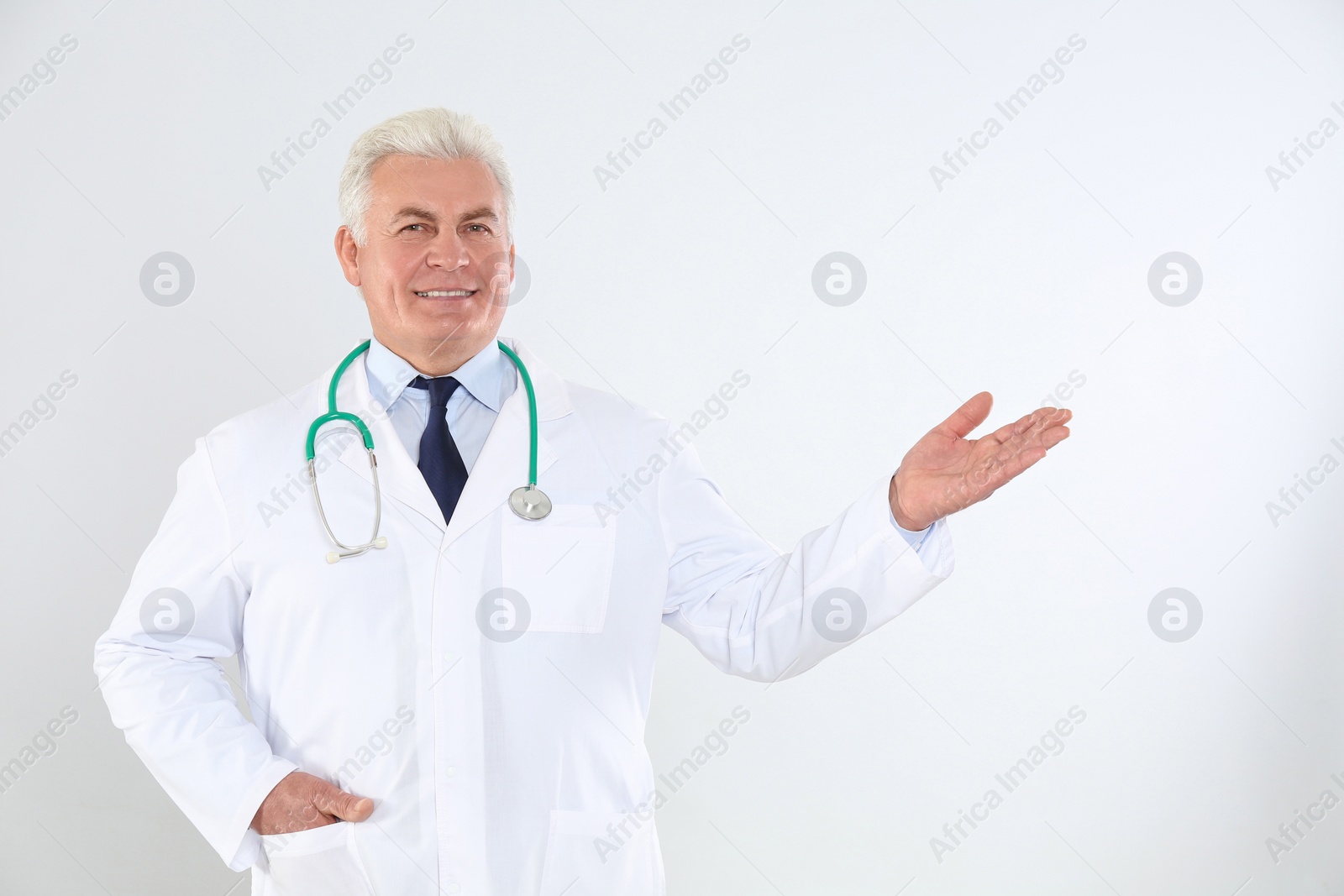 Photo of Portrait of senior doctor with stethoscope on white background