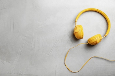 Photo of Stylish modern headphones and space for text on gray background, top view