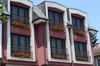 Photo of Building with beautiful flowers on balconies outdoors
