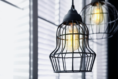 Image of Stylish metallic pendant lamp with Edison light bulb indoors