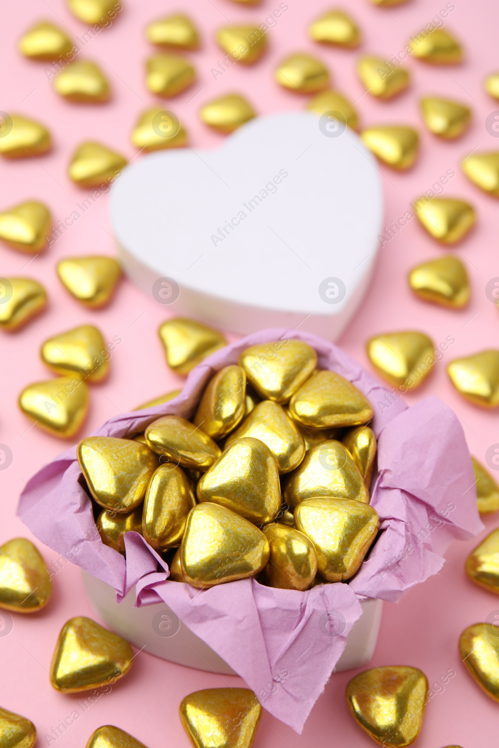 Photo of Box and delicious heart shaped candies on pink background