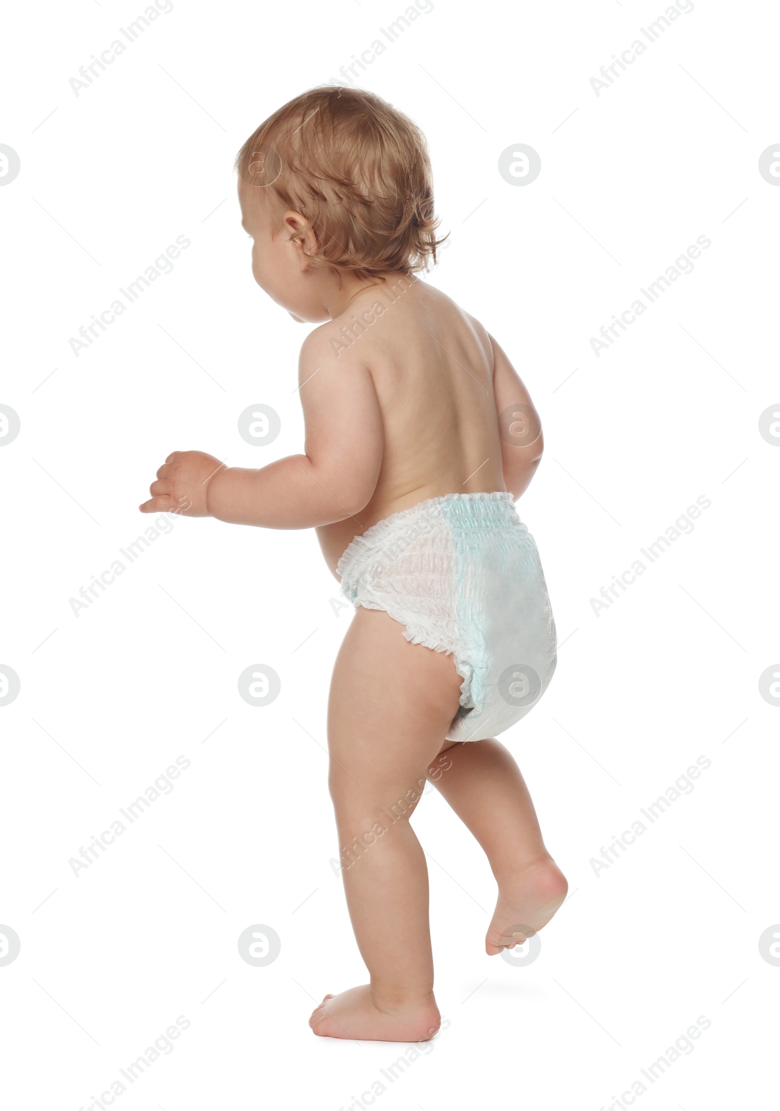 Photo of Cute baby in diaper learning to walk on white background