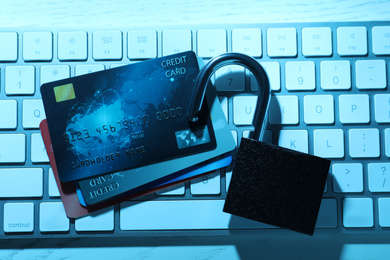 Photo of Credit cards, lock and computer keyboard on table, top view. Cyber crime