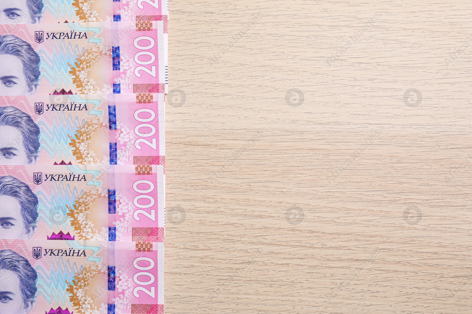 Photo of Ukrainian money on wooden background, flat lay. Space for text