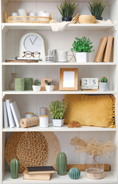 White shelving unit with plants and different decorative stuff