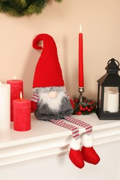 Photo of Cute Christmas gnome and festive decor on fireplace at home